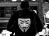 Man wearing a "Guy Fawkes" (from "V for Vendetta novel)  mask on his back.